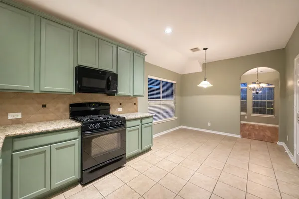 a kitchen with stainless steel appliances granite countertop a sink and a stove