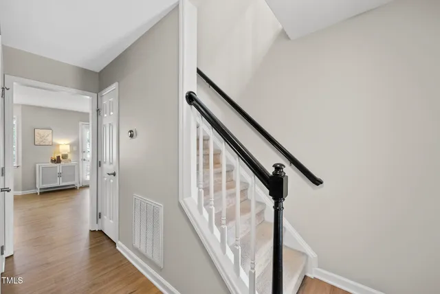 a view of a hallway with wooden floor and stairs