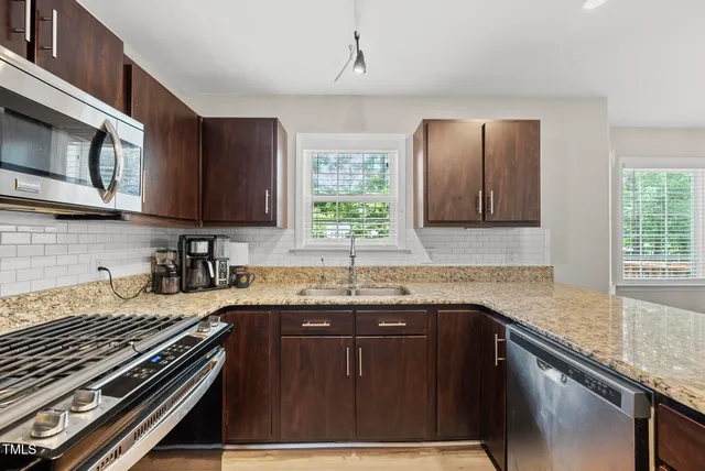a kitchen with granite countertop a sink stove and cabinets
