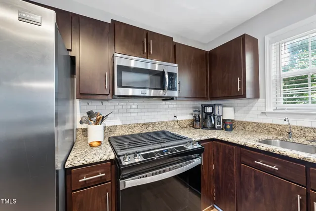 a kitchen with granite countertop a stove microwave and sink