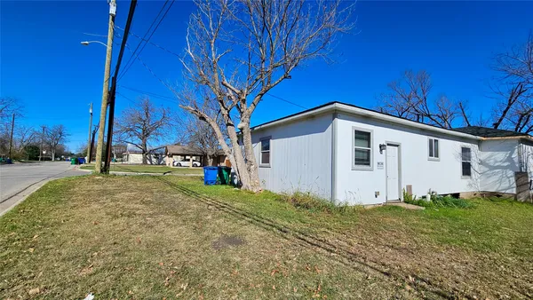 a view of a house with backyard and tree