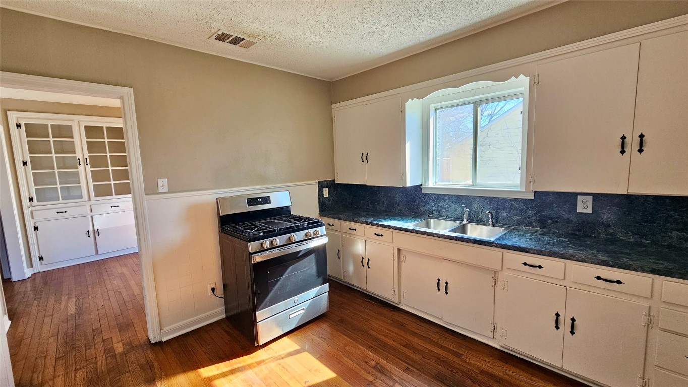 919 West 6th Street Taylor, TX 76574 - Photo 7 of 16 a kitchen with granite countertop a stove and a sink