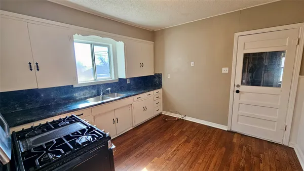 a kitchen with granite countertop a stove and a wooden cabinets