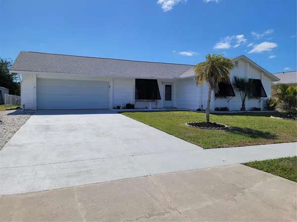 a view of a house with a yard and potted plants