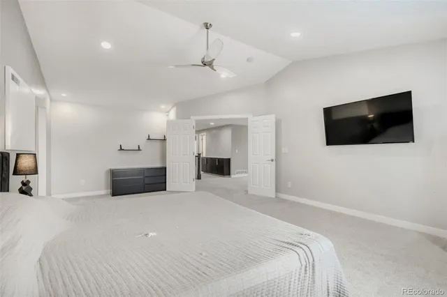 a large bedroom with a bed and a flat screen tv