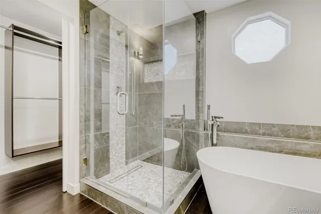 a bathroom with a tub a sink and a mirror