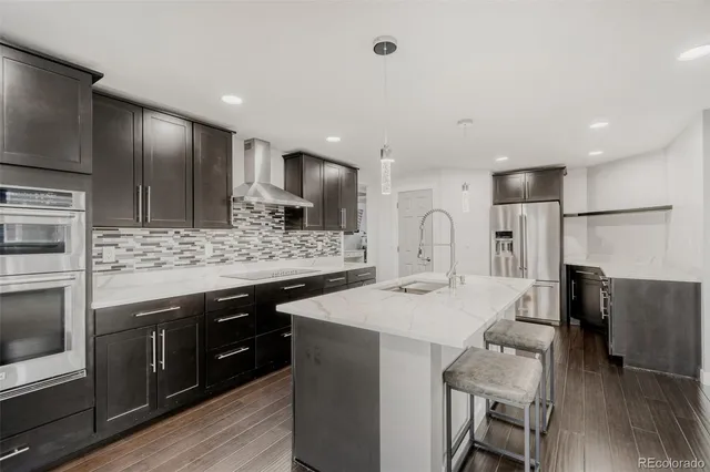 a kitchen with stainless steel appliances kitchen island granite countertop a sink and stove