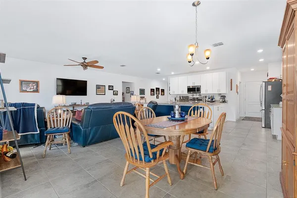 a view of a dining room and livingroom with furniture a flat screen tv and a clock