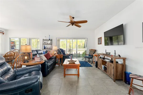 a living room with furniture kitchen view and a flat screen tv
