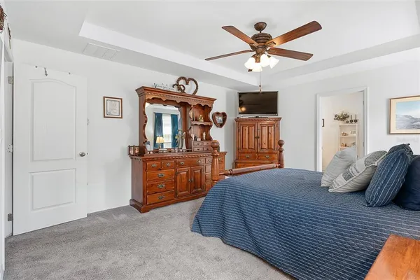 a bedroom with a bed and dresser with mirror