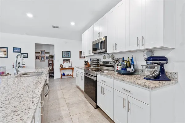 a kitchen with stainless steel appliances granite countertop a sink dishwasher stove top oven and cabinets