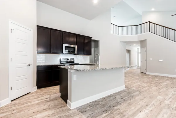 a view of kitchen with microwave stove top oven and cabinets
