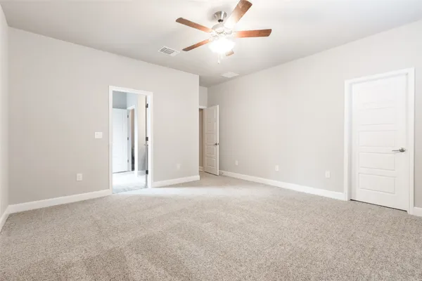 an empty room with closet and a chandelier fan
