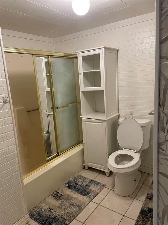 241 Aurora Street Rhome, TX 76078 - Photo 21 of 28 Bathroom with bath / shower combo with glass door and tile patterned floors