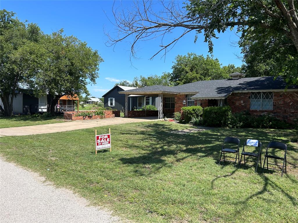 241 Aurora Street Rhome, TX 76078 - Photo 3 of 28 Ranch-style home with driveway, a front lawn, and brick siding
