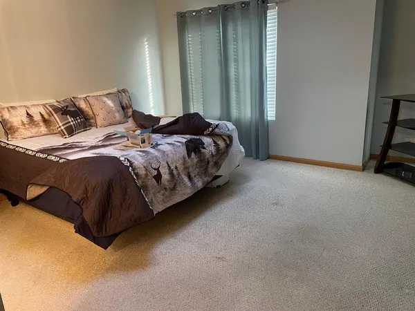a bed sitting in a bedroom next to a window