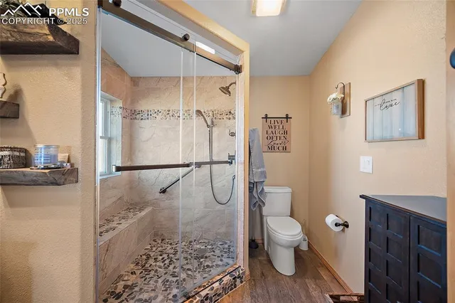 a bathroom with a granite countertop toilet a sink and a shower