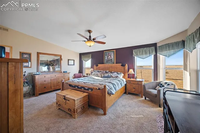 a spacious bedroom with a large bed and a chandelier