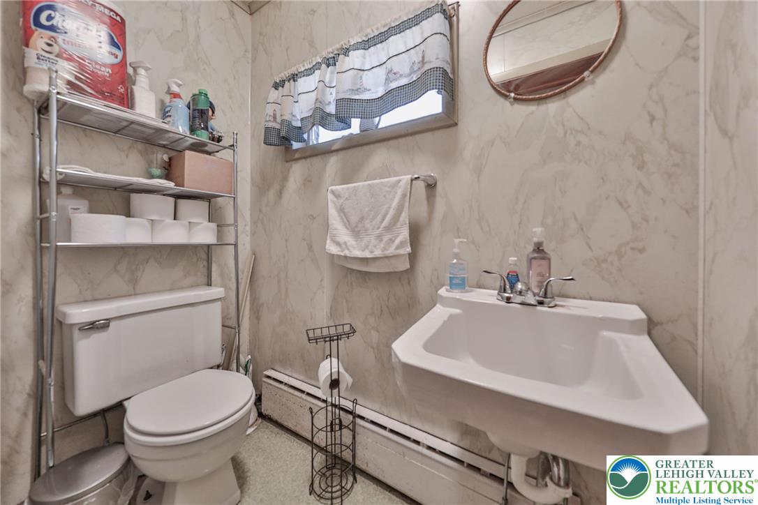 417 3rd Street Lehighton, PA 18235 - Photo 29 of 39 This functional bathroom features a wall-mounted sink and toilet, offering practical space for daily routines.