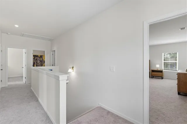 a view of a hallway with white walls and cabinet