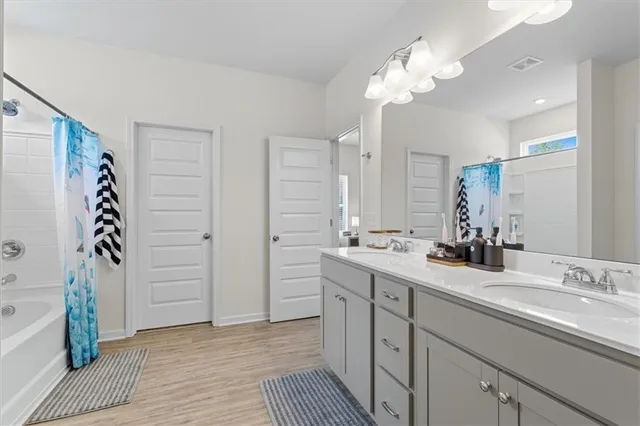 a bathroom with a double vanity sink mirror and shower
