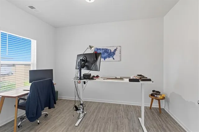 a view of a workspace with furniture and a window