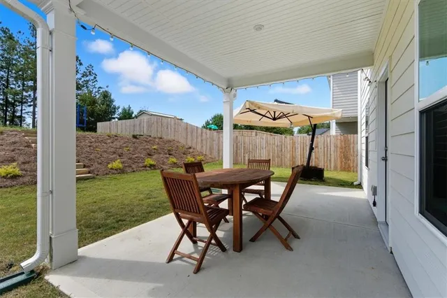 a view of a patio with a table chairs and a backyard