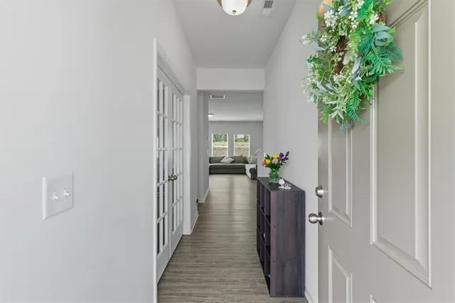 a view of a hallway with wooden floor and a potted plant