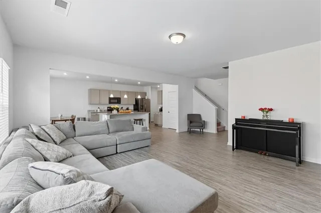 a living room with furniture and a wooden floor