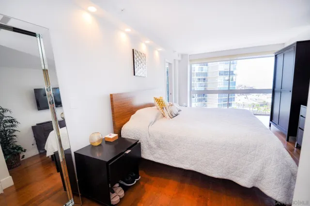 a bedroom with a bed and large windows