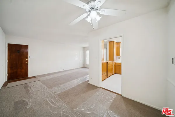 an empty room with fan and windows