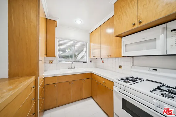 a kitchen with a sink a stove and cabinets