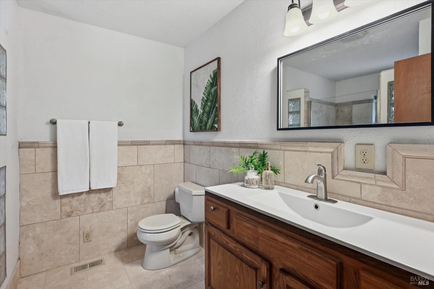 929 Helen Avenue Ukiah, CA 95482 - Photo 11 of 36 a bathroom with a toilet a sink and mirror