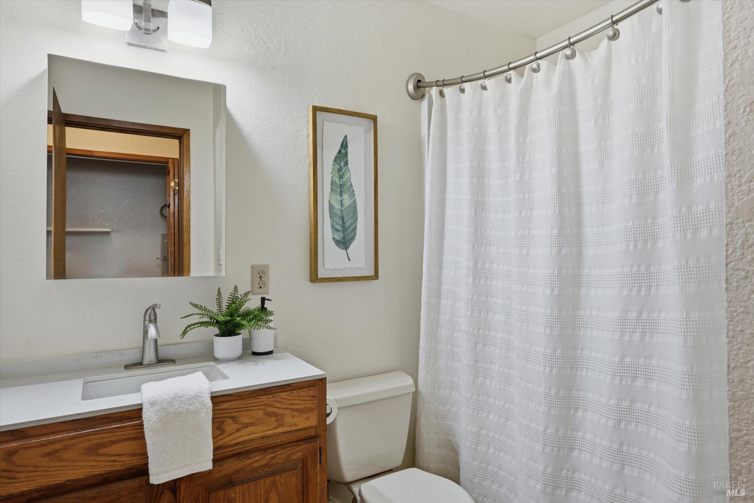 929 Helen Avenue Ukiah, CA 95482 - Photo 16 of 36 a bathroom with a granite countertop sink and a mirror