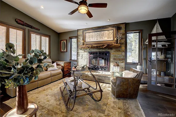 a living room with furniture a floor to ceiling window and potted plant