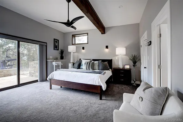 a bedroom with a large bed and a potted plant on the dresser