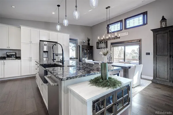 a large kitchen with lots of counter space a sink appliances and cabinets