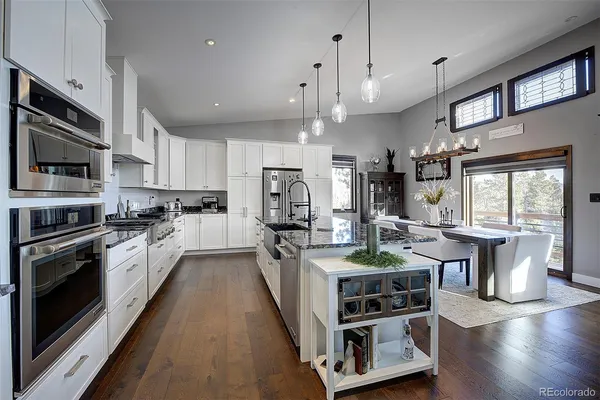 a kitchen with cabinets stainless steel appliances and wooden floor