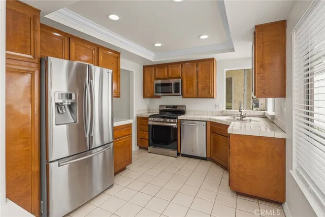 a kitchen with granite countertop a refrigerator stove top oven and sink