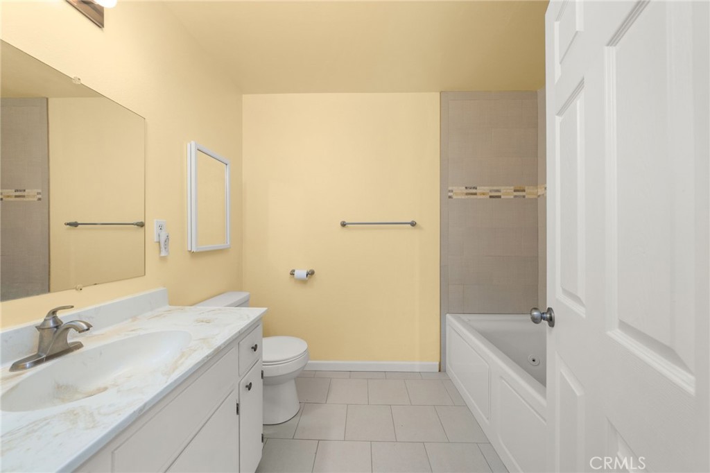 12610 Serrano Drive Yucaipa, CA 92399 - Photo 14 of 29 a bathroom with a granite countertop bathtub shower sink vanity and toilet