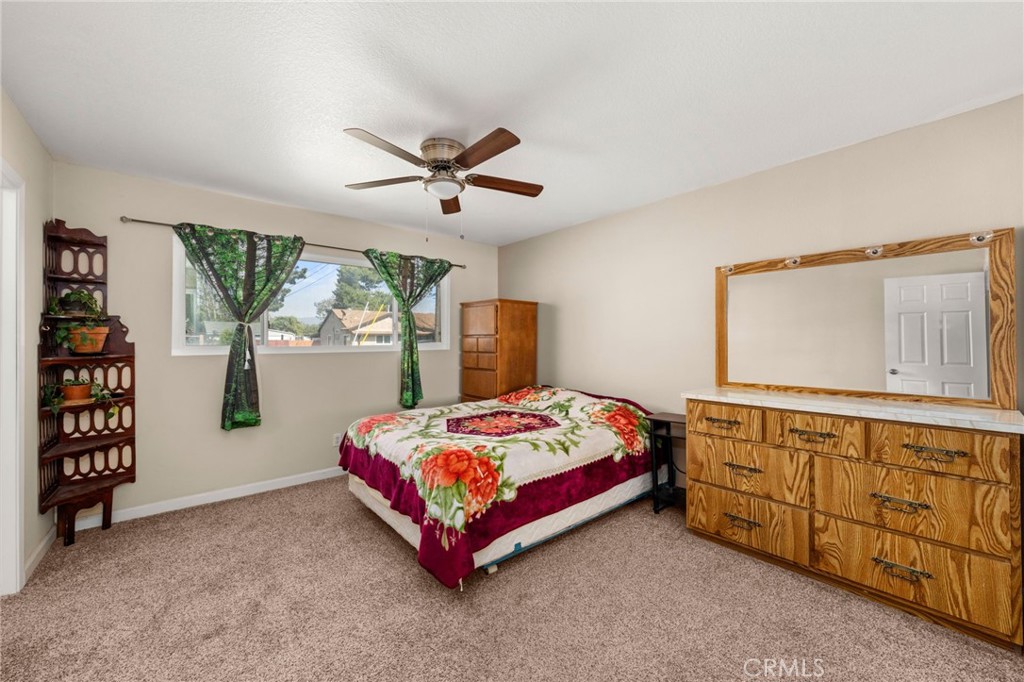 12610 Serrano Drive Yucaipa, CA 92399 - Photo 15 of 29 a bedroom with a bed a dresser and book shelf