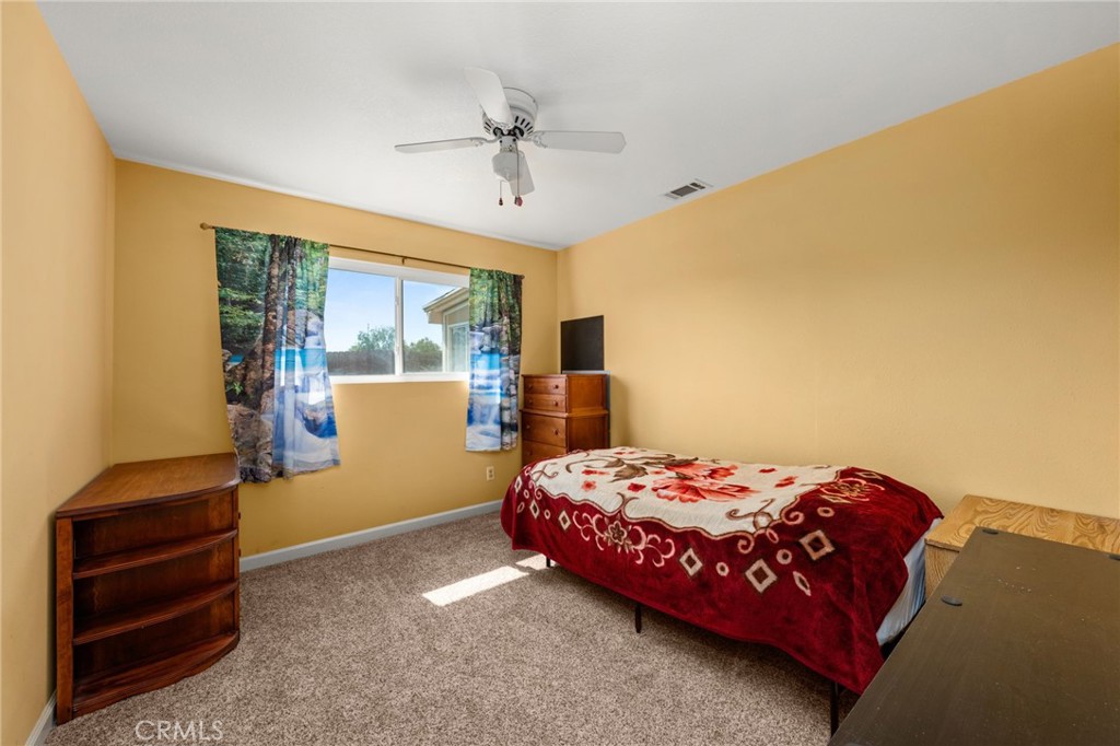 12610 Serrano Drive Yucaipa, CA 92399 - Photo 18 of 29 a bedroom with a bed and a dresser