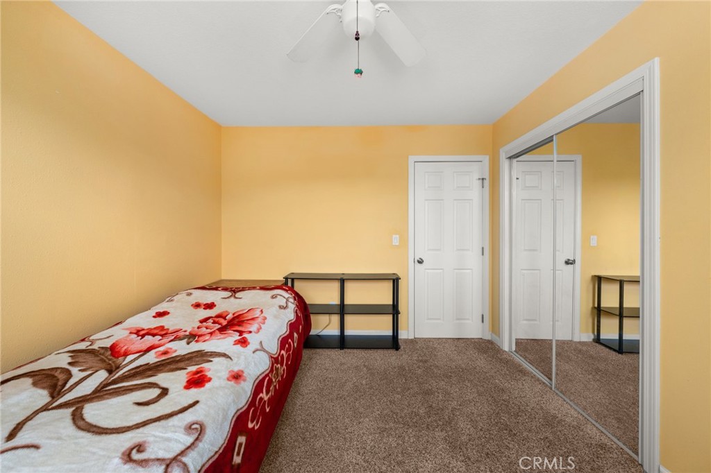 12610 Serrano Drive Yucaipa, CA 92399 - Photo 19 of 29 a bedroom with a bed and wooden floor