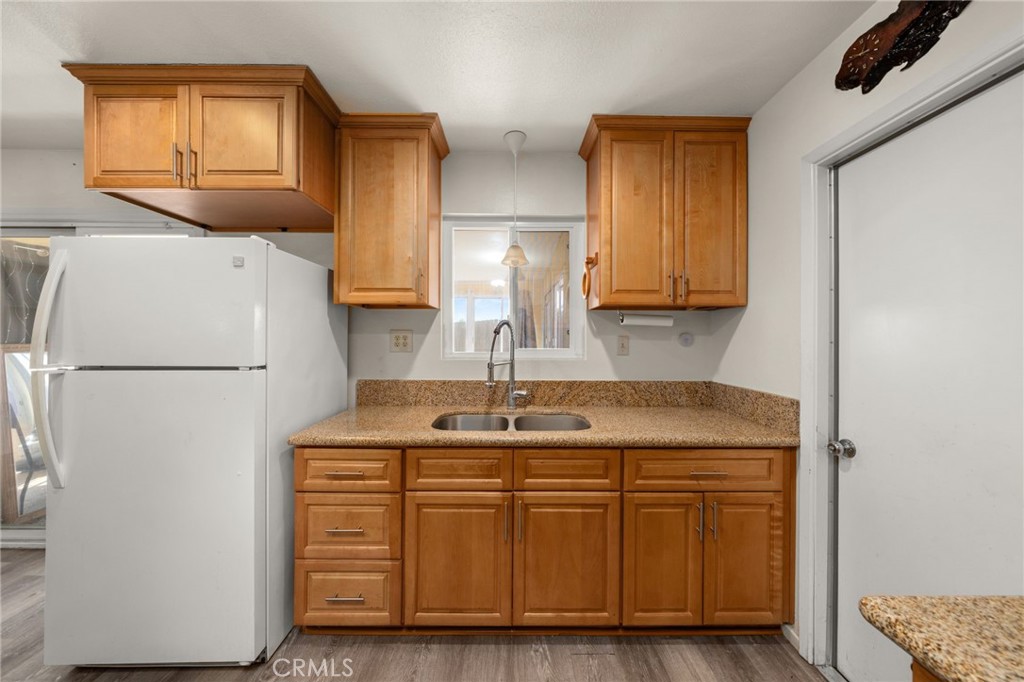12610 Serrano Drive Yucaipa, CA 92399 - Photo 7 of 29 a kitchen with cabinets a refrigerator and a sink