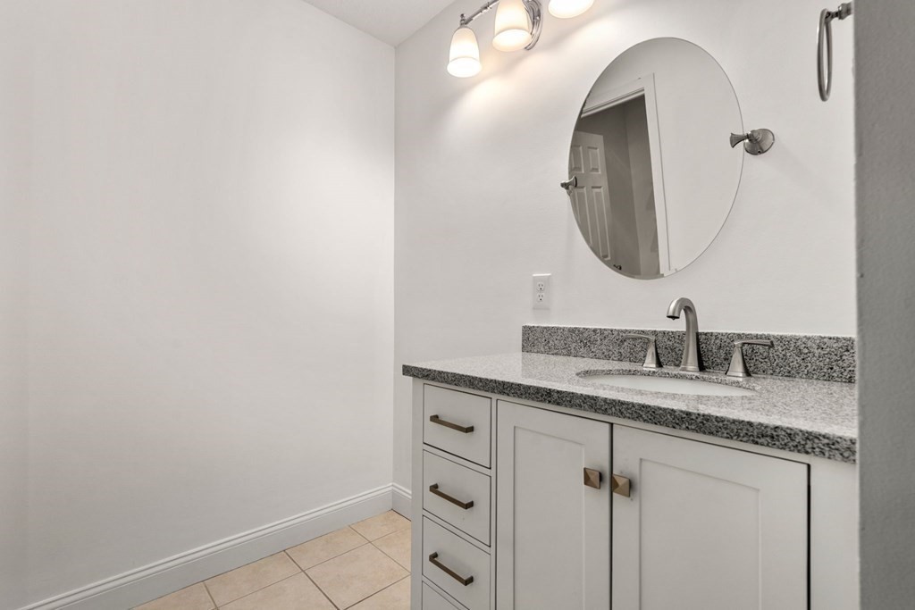 100 Brookside Drive, Unit F Andover, MA 01810 - Photo 14 of 22 a bathroom with a granite countertop sink and a mirror
