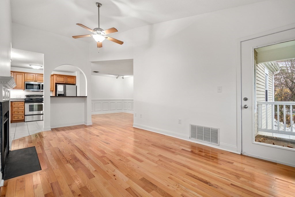100 Brookside Drive, Unit F Andover, MA 01810 - Photo 3 of 22 a view of a kitchen with a stove wooden cabinet wooden floor chandelier and windows