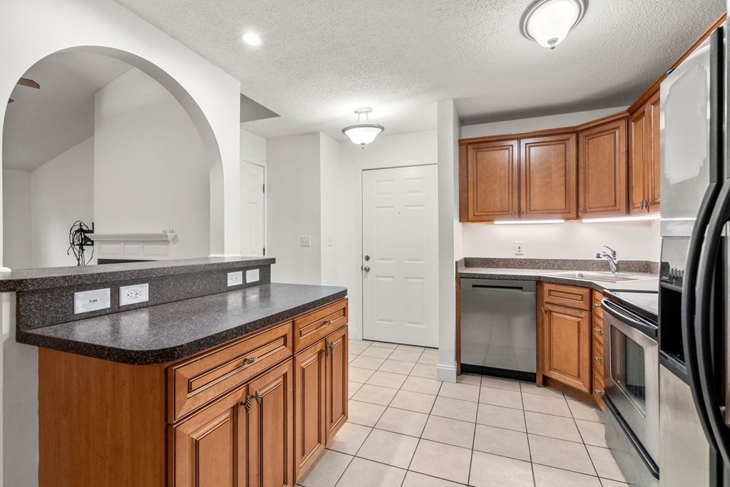 100 Brookside Drive, Unit F Andover, MA 01810 - Photo 5 of 22 a kitchen with stainless steel appliances granite countertop a sink stove and refrigerator