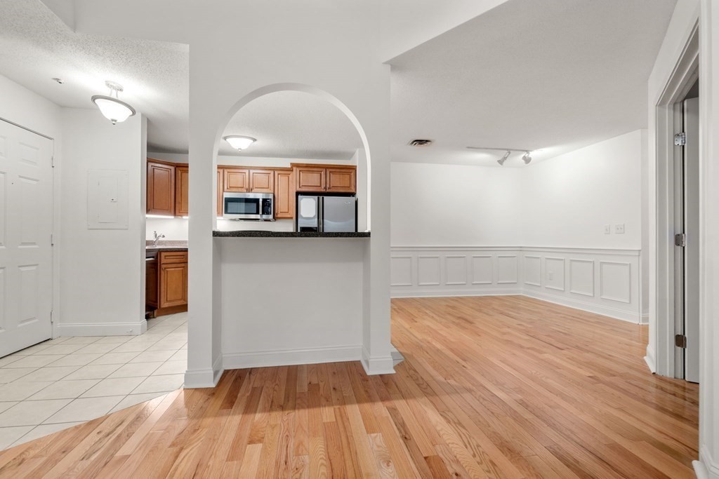 100 Brookside Drive, Unit F Andover, MA 01810 - Photo 9 of 22 a view of a room with wooden floor and a kitchen