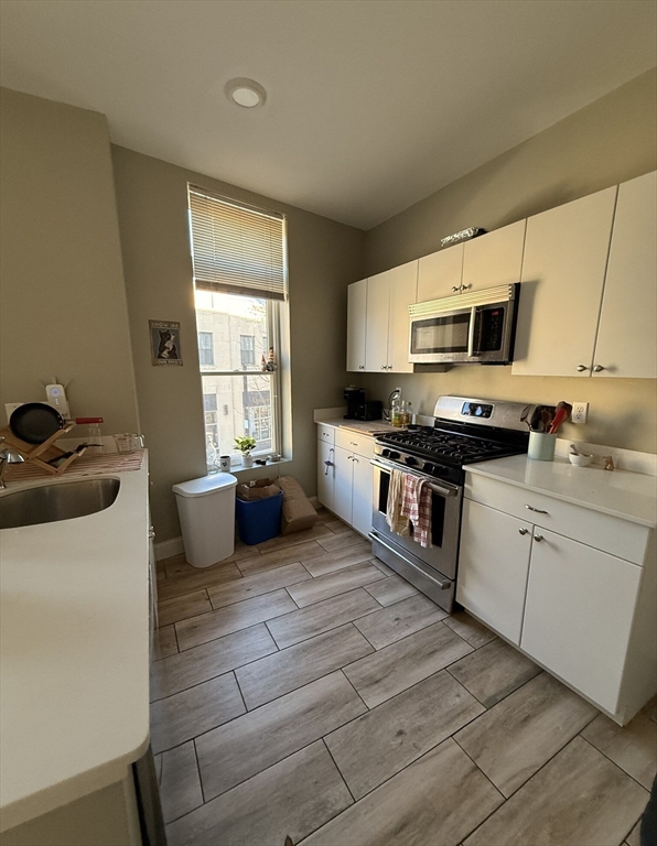 a kitchen with stainless steel appliances a stove a sink and a microwave