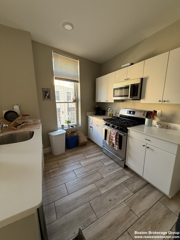 10 Roxbury Street, Unit 3 Boston, MA 02119 - Photo 1 of 11 a kitchen with stainless steel appliances granite countertop a stove a sink and a microwave